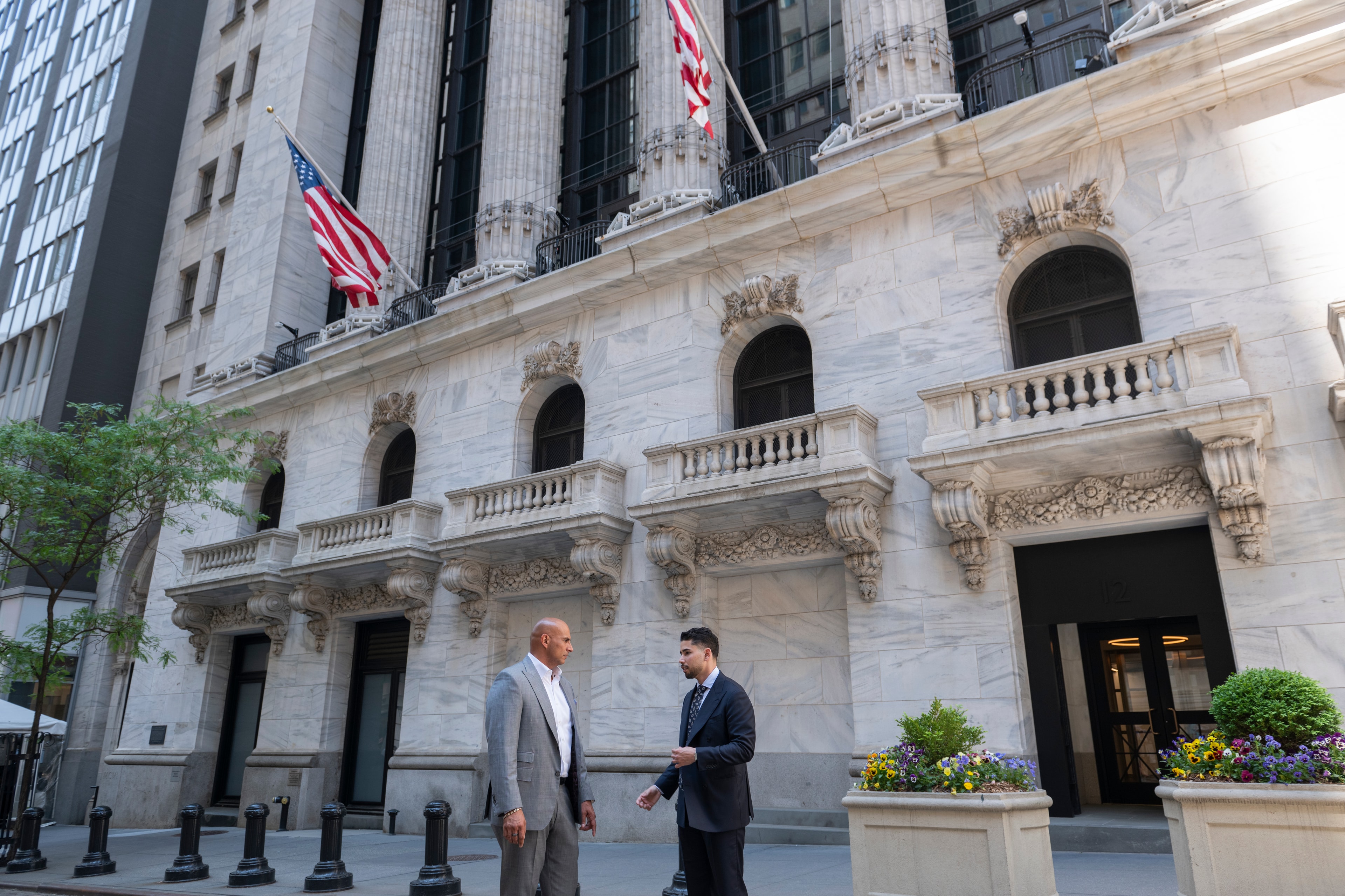 Omar Hafez in conversation with a colleague outside the New York Stock Exchange