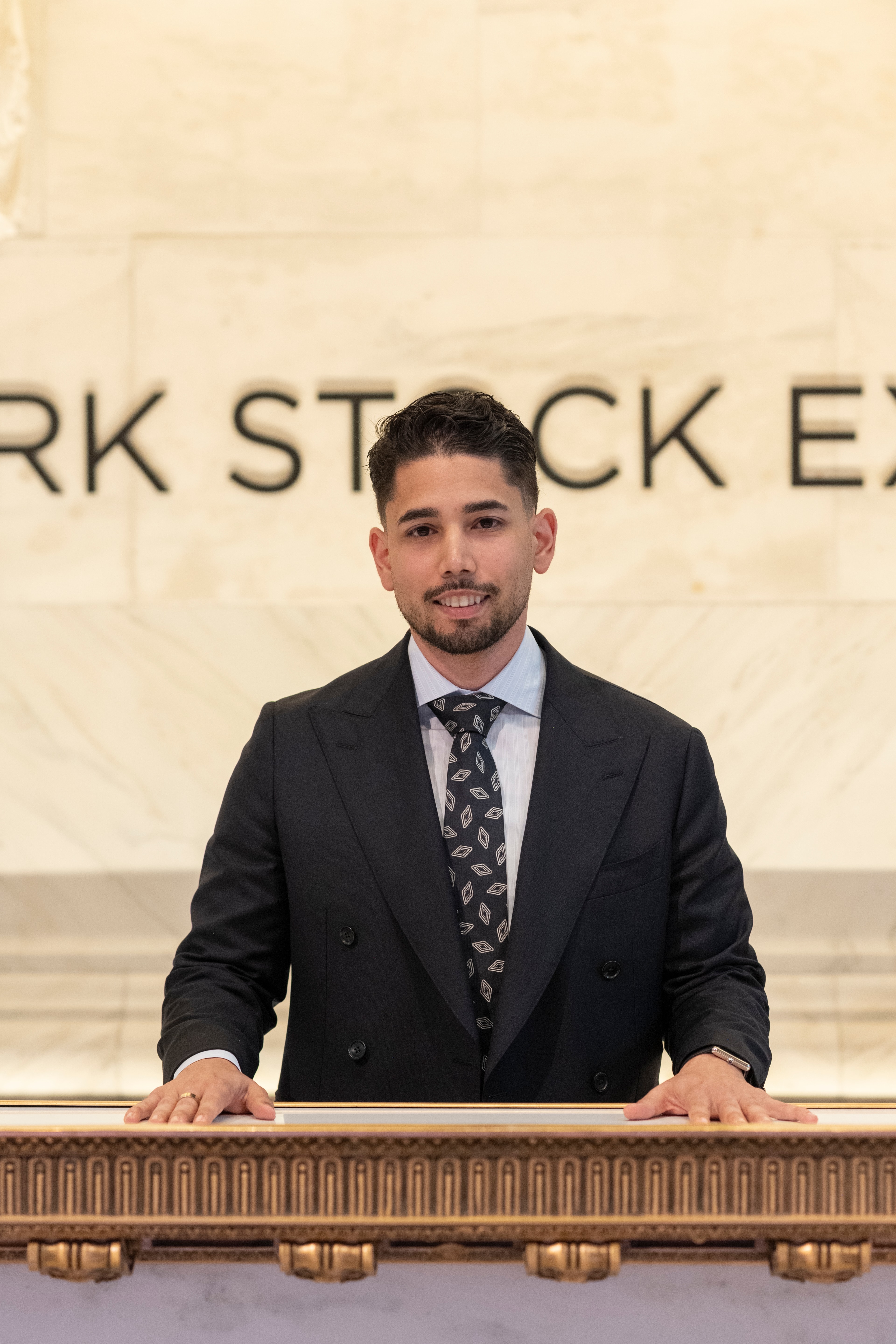 Omar Hafez at a lectern beneath the carved New York Stock Exchange lettering